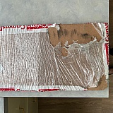 Original shipment - fiberboard broken in half, and the shrink wrap partly shredded.