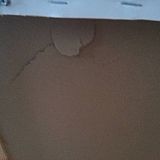 A crack in the back of the canvas, with a hole right through the canvas on the front.