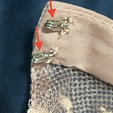 Sewn backwards, the open side of the latches are facing the fabric rather than facing out.