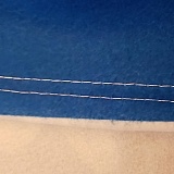 Printerpix showing top edge with white stitching and the white edge is not turned under properly, allowing the white from the back to show on the edges of the dark teal border.