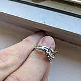 The side stone setting, next to the center, is empty, on both sides.